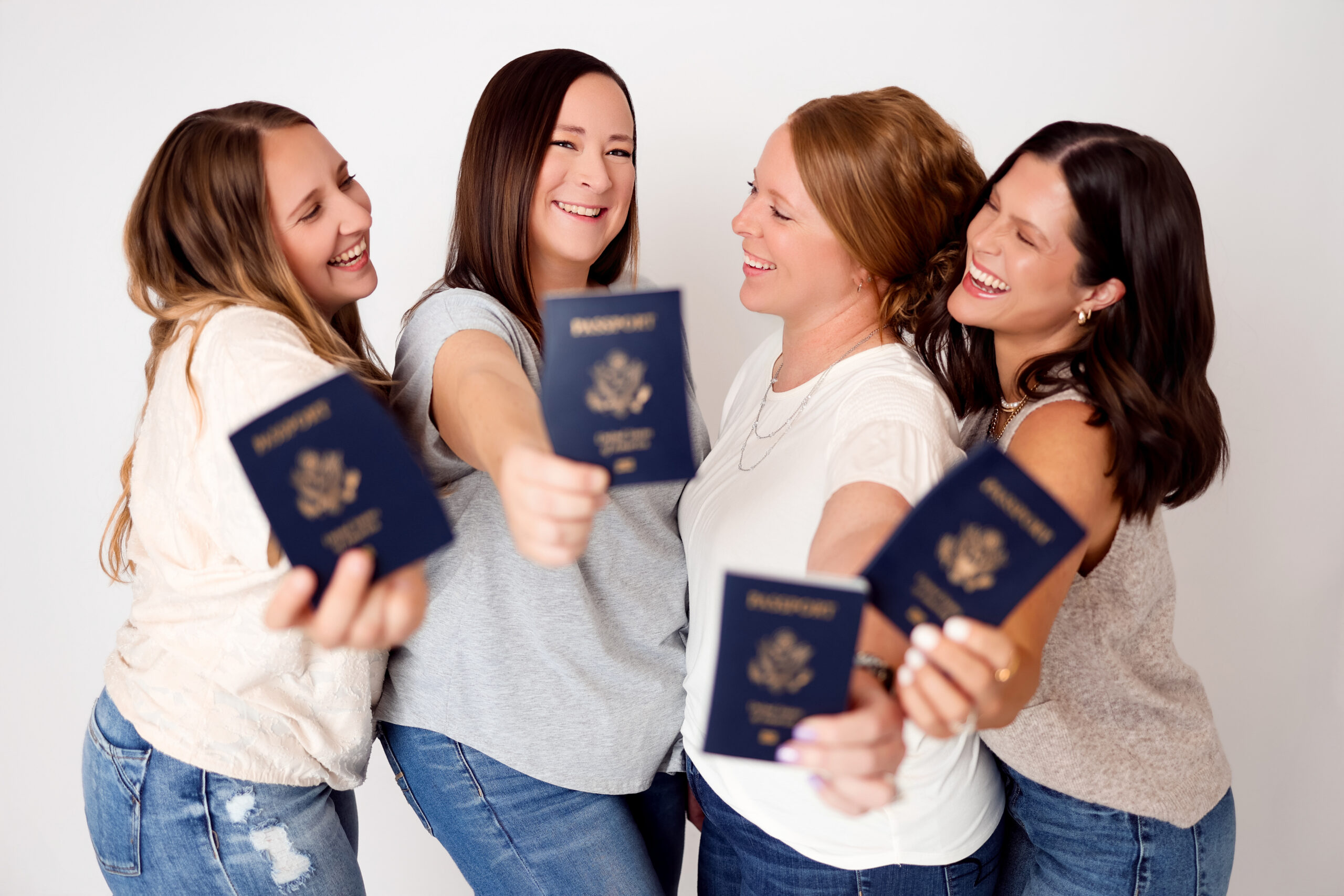 destination wedding travel agents at TBD Travel pose for photos with their passports.